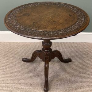 19th century oak tripod table, circular tilt top carved with a band of scrolls within a moulded